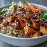 Freshly cooked spiced chicken and caramelized sweet potatoes fill a bowl with fluffy quinoa, topped with crunchy red cabbage slaw and drizzled with tangy hot honey mustard dressing.