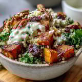 A vibrant Harvest Kale Quinoa Bowl drizzled with creamy lemon tahini dressing, dotted with sweet cranberries, perfect for a healthy autumn weeknight meal.