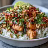 Creamy Thai chicken coconut bowl with jasmine rice, fresh vegetables, and fragrant herbs in a vibrant, satisfying dish.  
