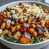 Vibrant autumn-inspired vegetarian bowl featuring wild rice, roasted veggies, and creamy feta with crunchy almonds and fresh apples.  