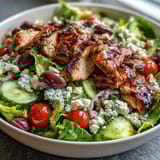 Colorful Greek Salad Bowl with Grilled Chicken, topped with creamy feta and Kalamata olives, perfect for a healthy, protein-packed lunch or dinner.  