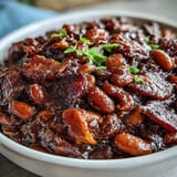 Smoky and sweet Juneteenth baked beans with crispy bacon, perfect for your picnic table.