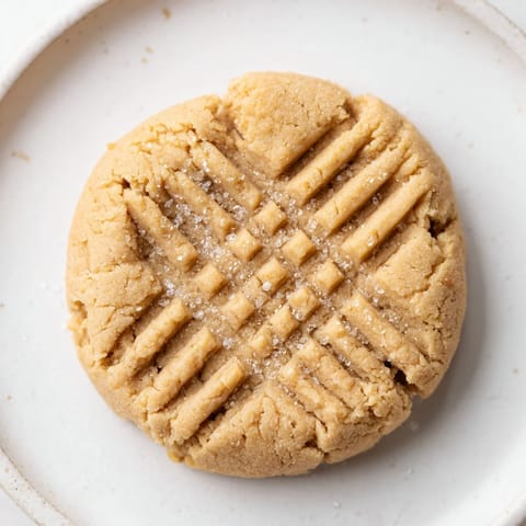 Soft, chewy peanut butter cookies awaiting a cold glass of milk, perfect for dessert.