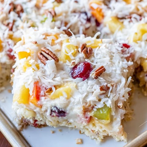 A close-up of a fruit cocktail cake shows the tender crumb and sweet, fruity pieces.