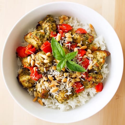 Hearty Chicken Pesto Rice Bowl served on warm rice with a vibrant green basil pesto sauce.