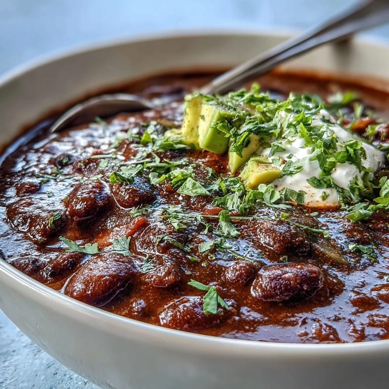 A comforting pot of Black Bean Soup simmering on the stove, featuring carrots and spices for a flavorful meal.