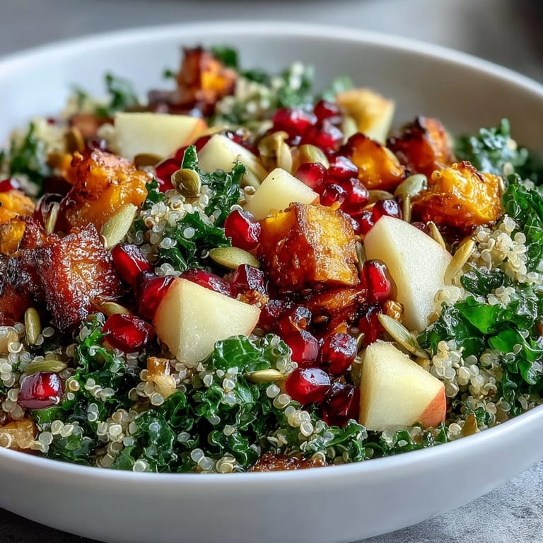 Close-up of a Kale Harvest Grain Bowl, revealing fluffy quinoa, massaged kale, and crunchy pepitas with a light drizzle.